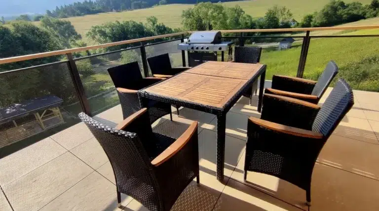 Stôl s šiestimi stoličkami a grilom na balkóne