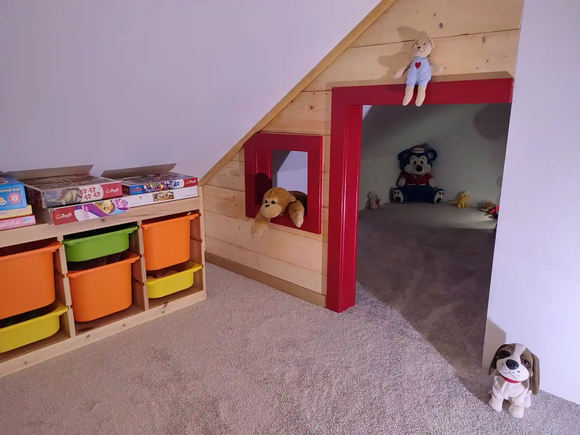 Detský kútik pod strechou s malým priechodom, poličkou s hračkami a plyšákmi.